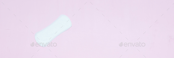 White ladies panty liner on bright pink paper background. Top view, close up copy space, flat lay