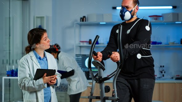 Medical researcher talking with sportsman while measuring his endurance