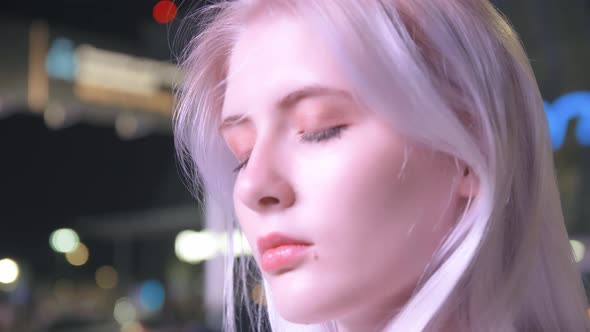 Portrait of a Young Beautiful Woman with White Hair Against the Backdrop of Illumination of the alt
