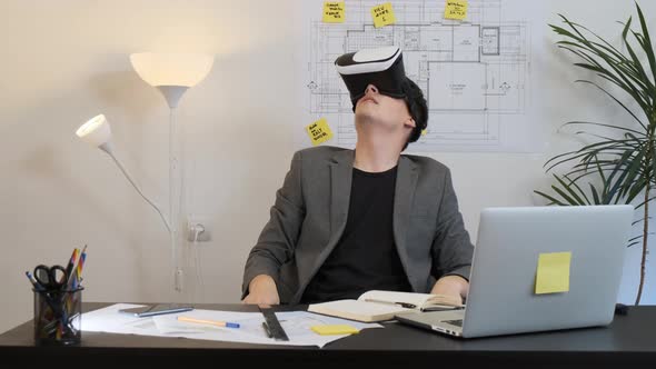 Male Architect in Virtual Reality Helmet Uses Gestures To Manage a Project alt
