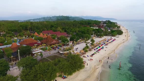 Fantastic arcing shot of the epic beach and ocean with tons of tourists hanging out. alt