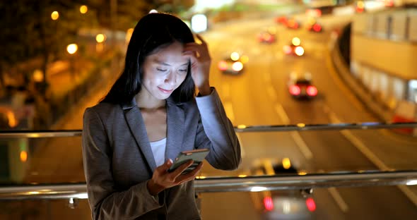 Business woman working on mobile phone at night 