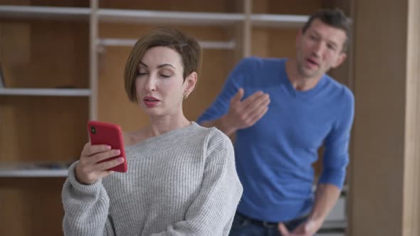 Portrait of Egoistic Wife with Vainglorious Facial Expression Surfing Social Media on Smartphone As alt