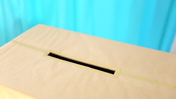 hand holding a ballot paper for voting at a polling station during elections or referendum. alt