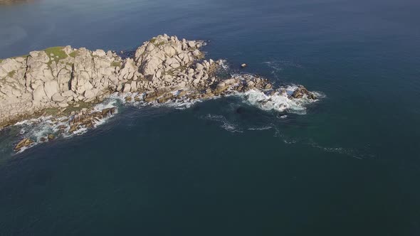 Aerial View of a Beautiful Small Rocky Island Surrounded By Clear Blue Sea alt