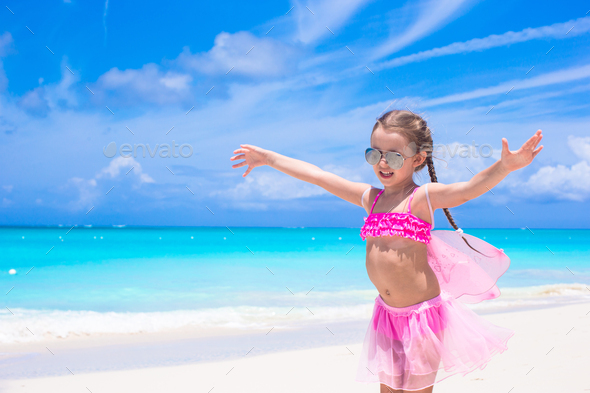 Funny little girl have fun on beach summer vacation Stock Photo by  travnikovstudio
