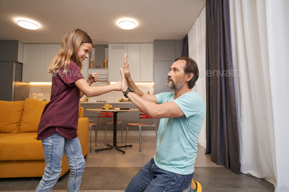 Girl is learning self-defense techniques from palms of adult man