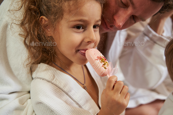 Portrait of smiling girl with dad eating tasty food