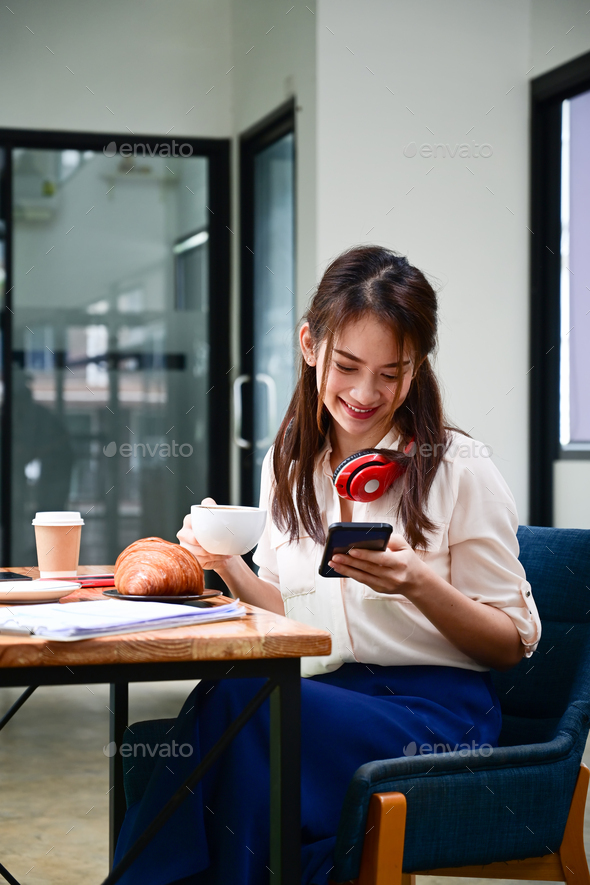 Smiling young female sitting coffee shop and using smart phone. Stock ...