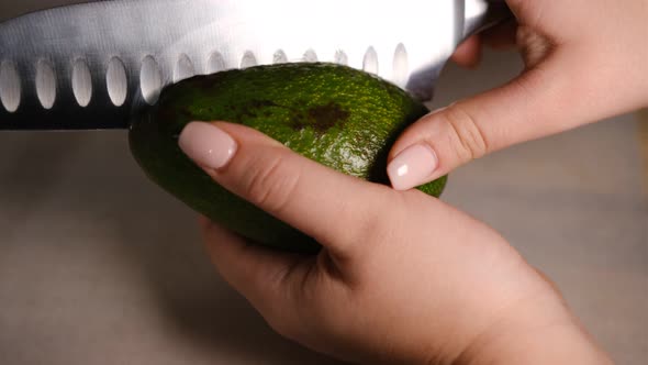 Female hands cut avocado in half. Fresh ripe avocado, Healthy breakfast, Vegetarian food alt