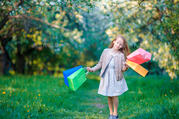 adorable-little-girl-with-shopping-bags-outdoors-in-apple-garden-stock