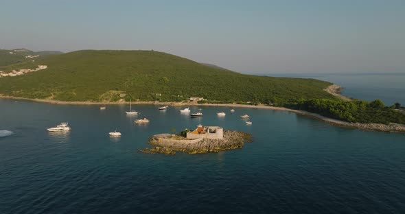aerial orbit shot of Otocic Gospa island with fortress arza, boats and yachts on background alt