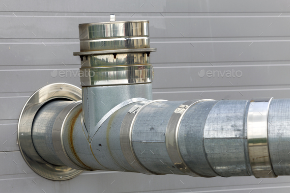 Metallic exhaust smoke pipes installed on house exterior wall