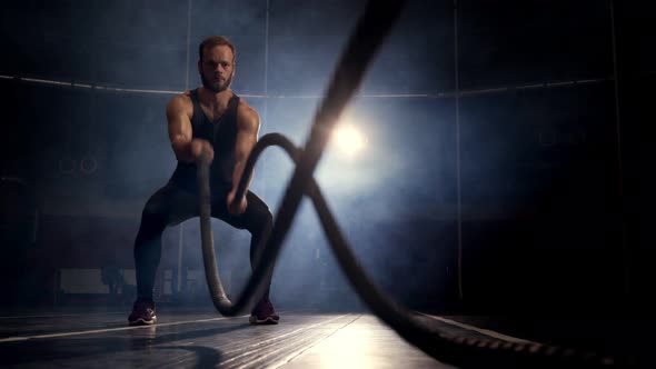 Male Athlete Training Using Battle Ropes Workout Exercise