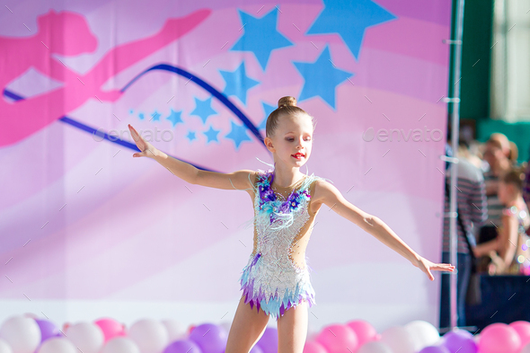 Little beautiful gymnast on carpet. Adorable gymnast participates in ...