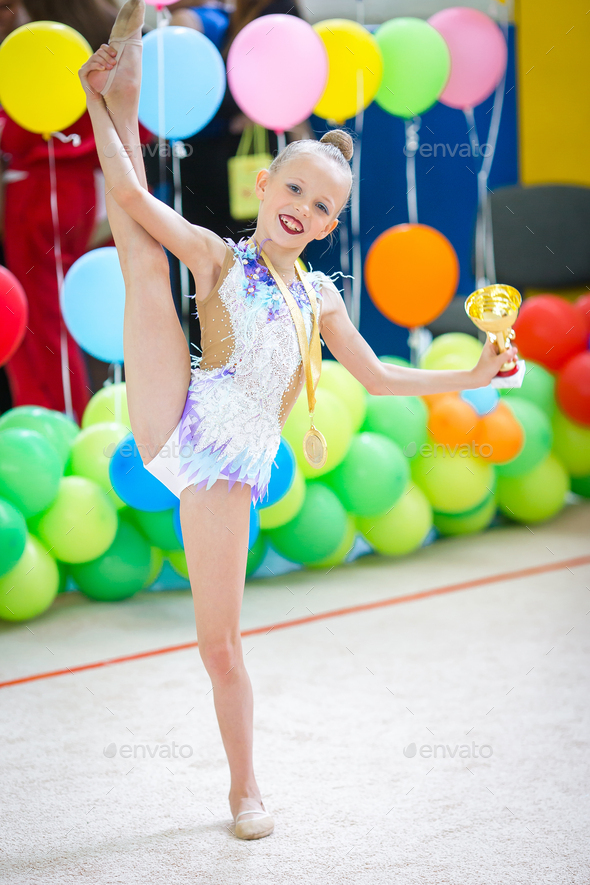 Beautiful little active gymnast girl with her performance on the carpet ...