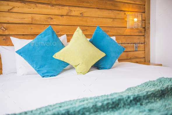 Luxury bedroom home interiors at a boutique hotel and house with blue cushions, bed and bedside ligh