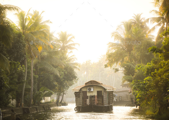Houseboat tourist boat trip on an excusrion in the Kerala backwaters at sunset near Alleppey, Alappu - Stock Photo - Images