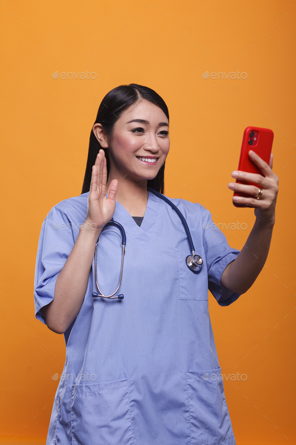 Smiling asian caregiver in remote telehealth videocall with patient while having online consultation