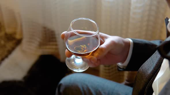 Unrecognizable Businessman Holding Glass with Whiskey Tasting Alcohol Drink alt