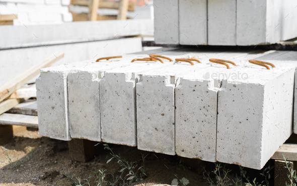 Concrete foundation building long gray blocks, close-up. Stone narrow slabs lying in row on