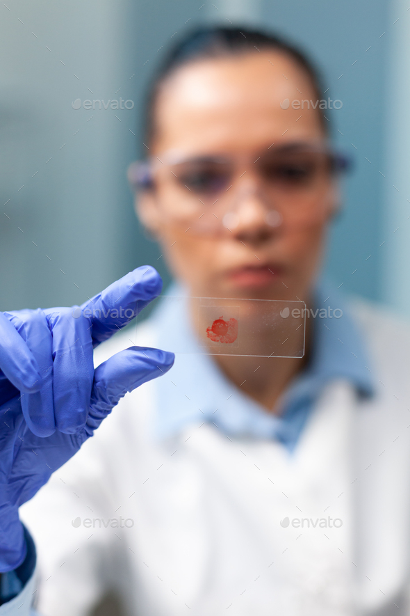 Chemist researcher holding glass with blood sample working at