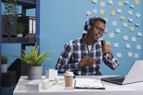 Business person in breaktime at work singing music while wearing audio headset
