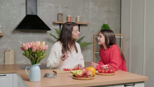 Mother Talks to Her Daughter While She Prepares the Vegetable Salad alt
