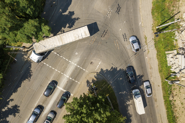 Top down aerial view of busy street intersection with moving cars traffic