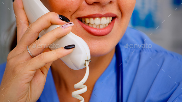 Close up of specialist practitioner talking at phone during telehealth - Stock Photo - Images