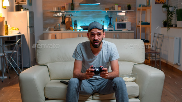 Upset pro gamer sitting in front of television losing soccer video games
