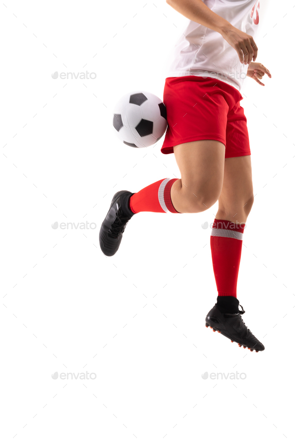 Low section of biracial young female player kicking soccer ball with back heel while playing soccer