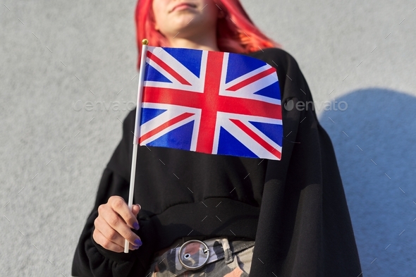 Female student teenager with British flag, gray outdoor wall background