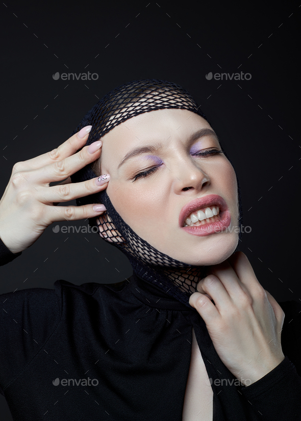 Woman with nylon stocking mesh on head. Black mesh bandage on face woman in black dress with a low