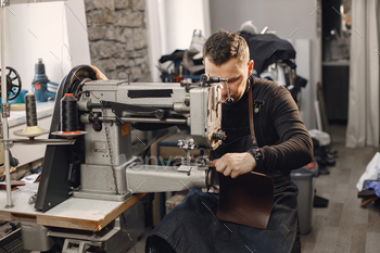 Leather craftsman working on a leather sheet using a sewing machine