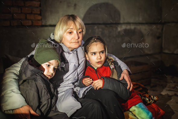 Grandmother hugs little Ukrainian kids, they sit out the attack in a bomb shelter