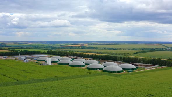 Agricultural farm for bio production. Biogas plant on green nature background. alt