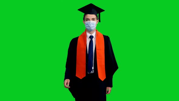 Graduating Student In Protective Mask And Gown Walking Towards The Camera