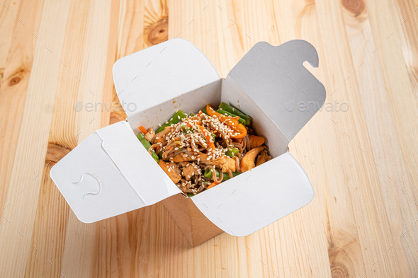 Udon noodles with chicken, green bean, bell pepper and sesame in take away box