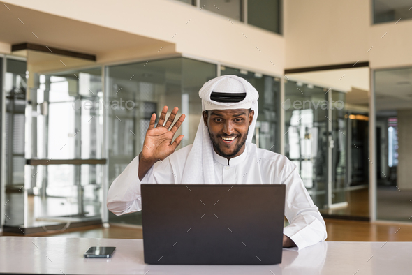 Young African Muslim man using laptop computer at office