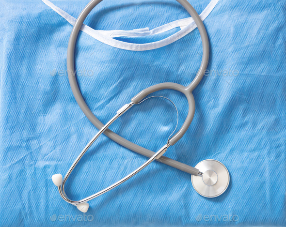Medical stethoscope on blue surgical coat. Health cardiology and hospital concept, overhead