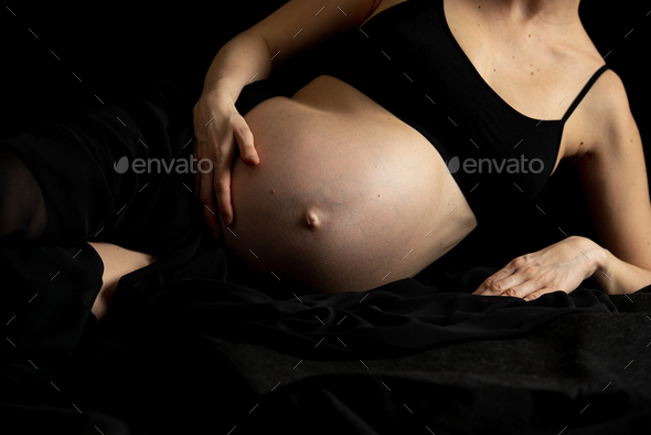 Pregnant woman in black sheet