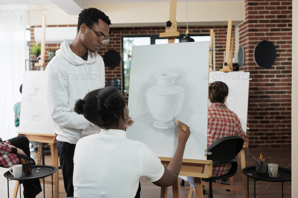 Painter teacher explaining illustration technique to student