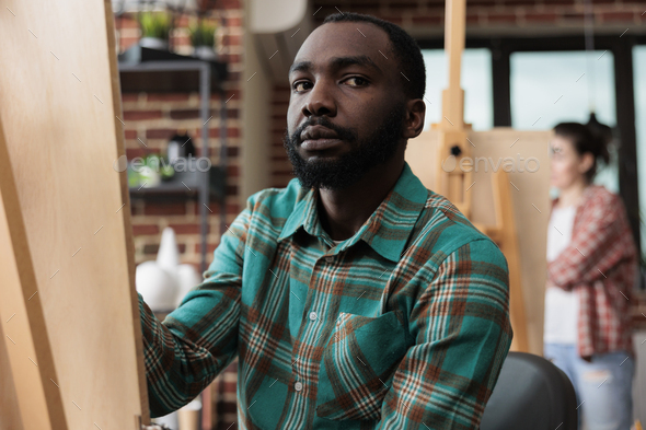 Portrait of creative artist man drawing vase model on canvas