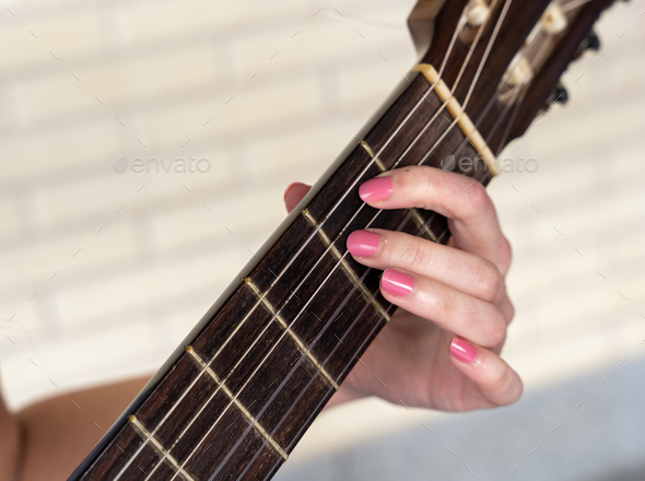 Crop female musician playing guitar