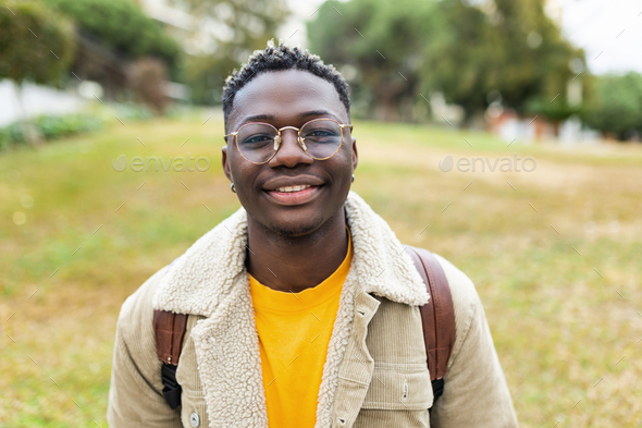 Smiling african young student man looking at camera outdoors - Stock Photo - Images