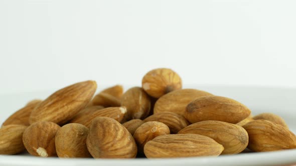 Healthy nuts almonds rotate on a white background 360. Eco cereals vegetarian. Nuts on a white plate