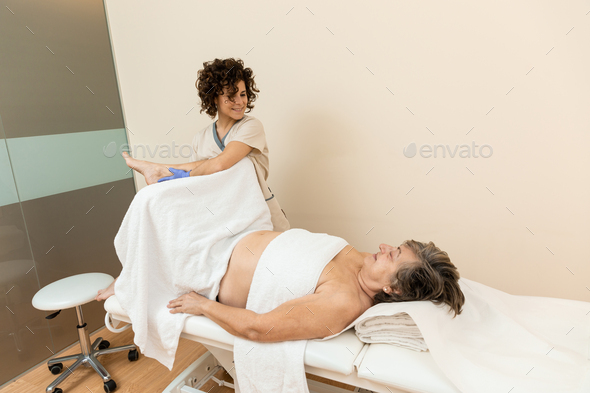 Gynecologist lifting patient\'s leg for medical examination
