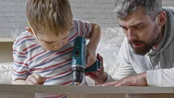 Little Boy Using Electric Screwdriver alt