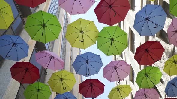 Street decorated with multi colored umbrellas hanging